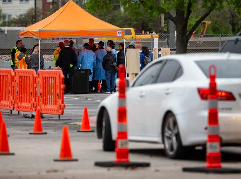 People wait in their cars for screening at Dallas County's first mobile COVID-19 testing...