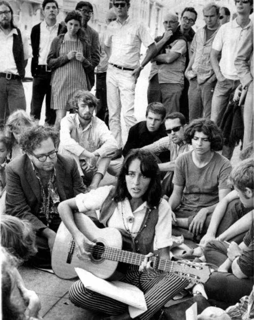 Folk singer Joan Baez sits at the corner of Haight and Ashbury in San Francisco, serenading...