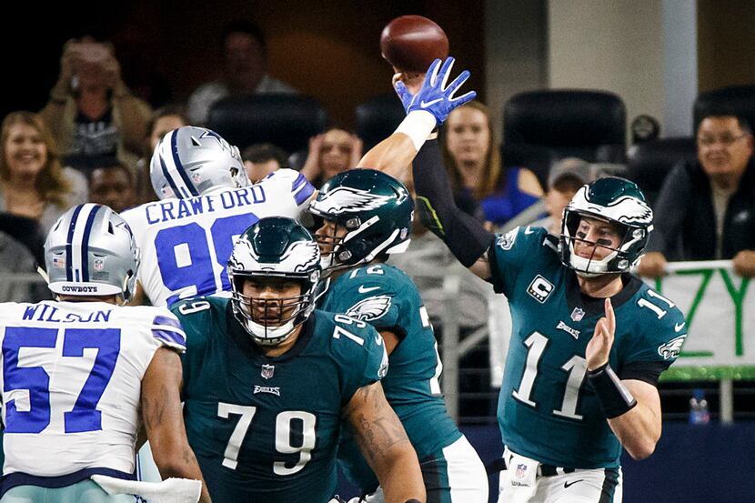 Philadelphia Eagles quarterback Carson Wentz (11) throws a pass under pressure from Dallas...