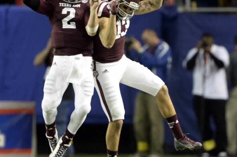 Texas A&M Aggies quarterback Johnny Manziel (2) celebrates with wide receiver Mike Evans...