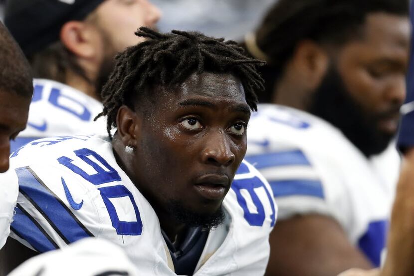 Cowboys defensive end Demarcus Lawrence sits on the bench during an NFL football game...