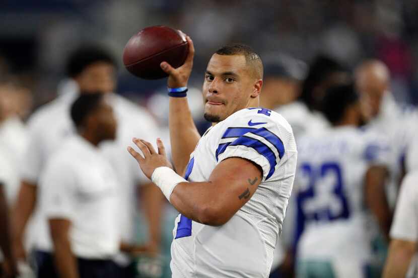 Dallas Cowboys' Dak Prescott throws a warm up pass during an NFL football game against the...