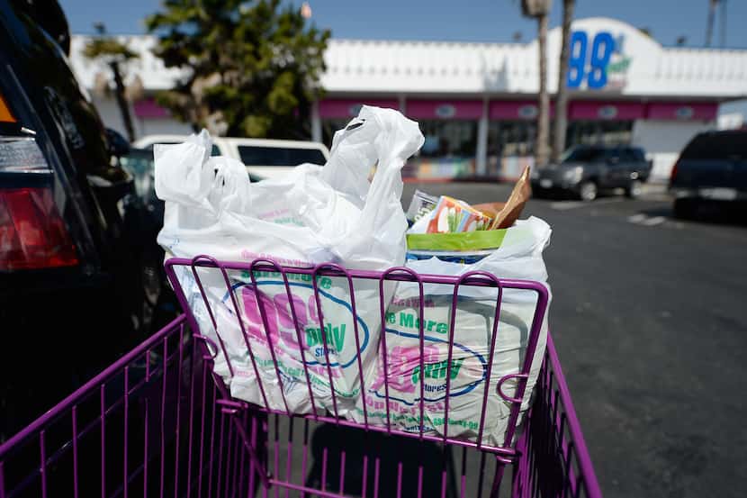 Shoppers use plastic grocery bags after shopping at the 99 Cents Only Store on June 18,...