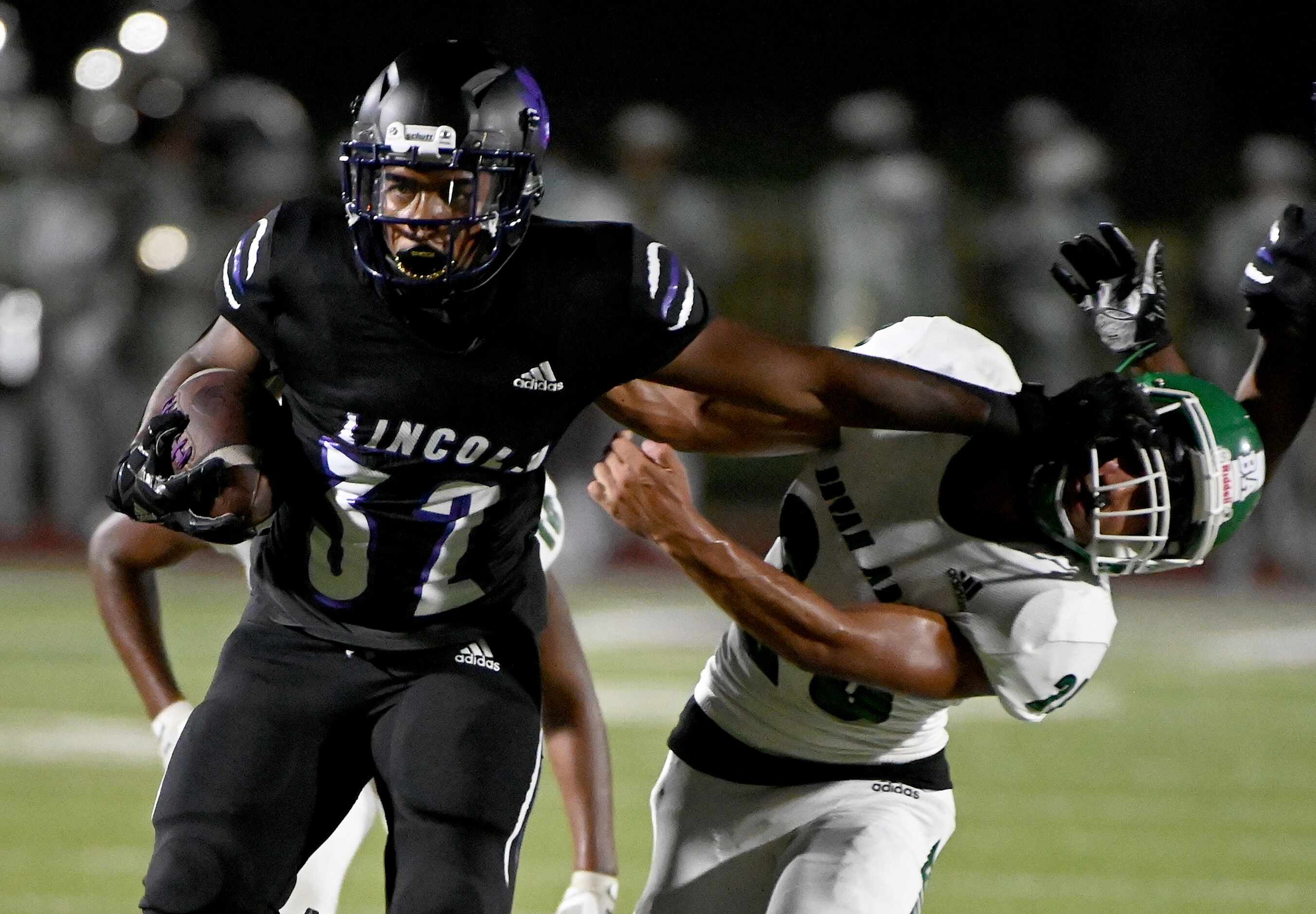 Lincoln’s Kievaughn Gipson (32) stiff arms Bryan Adam’s Jonathan Medrano (20) in the first...