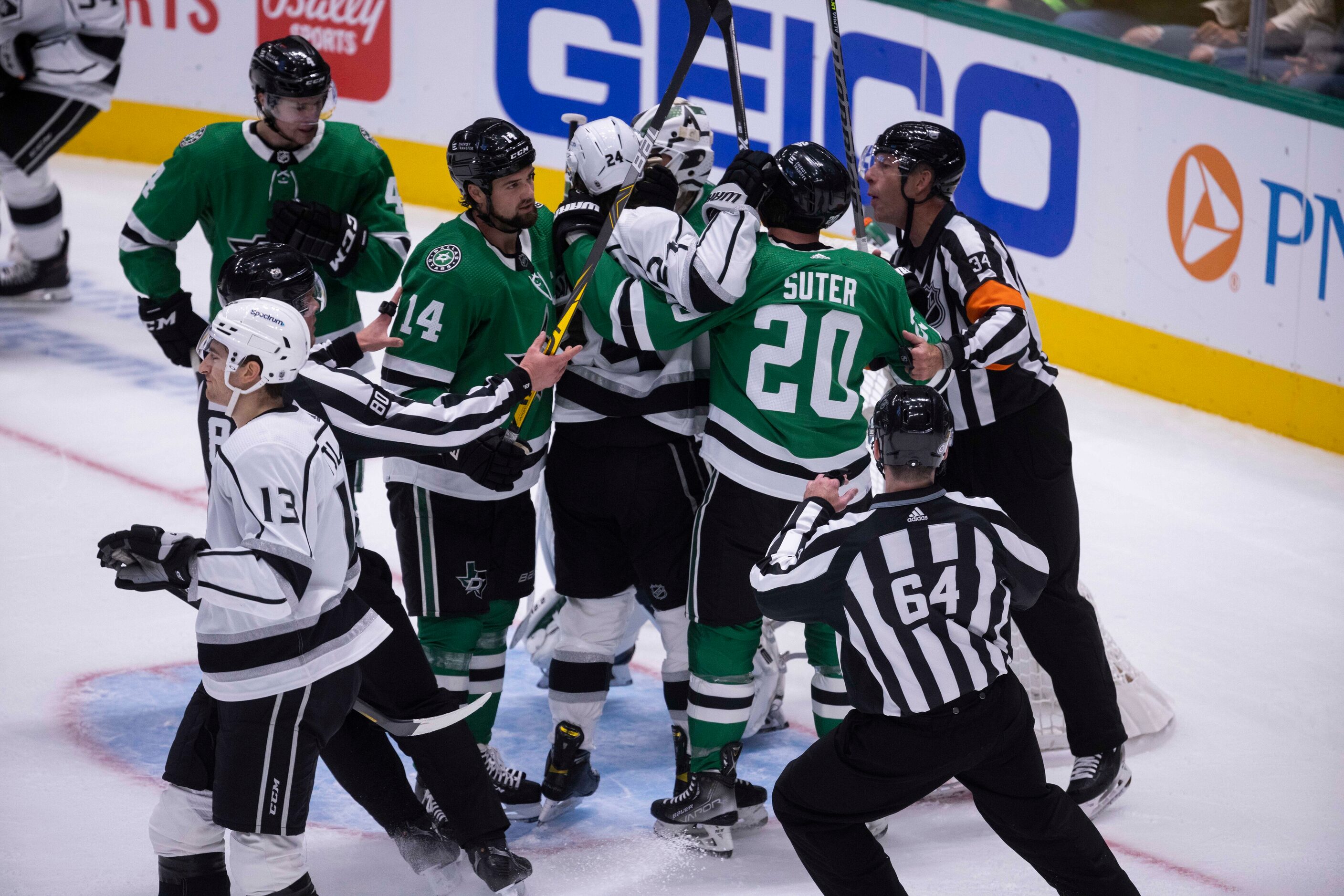 Referees break up a fight during the first period of a Dallas Stars home opener against the...