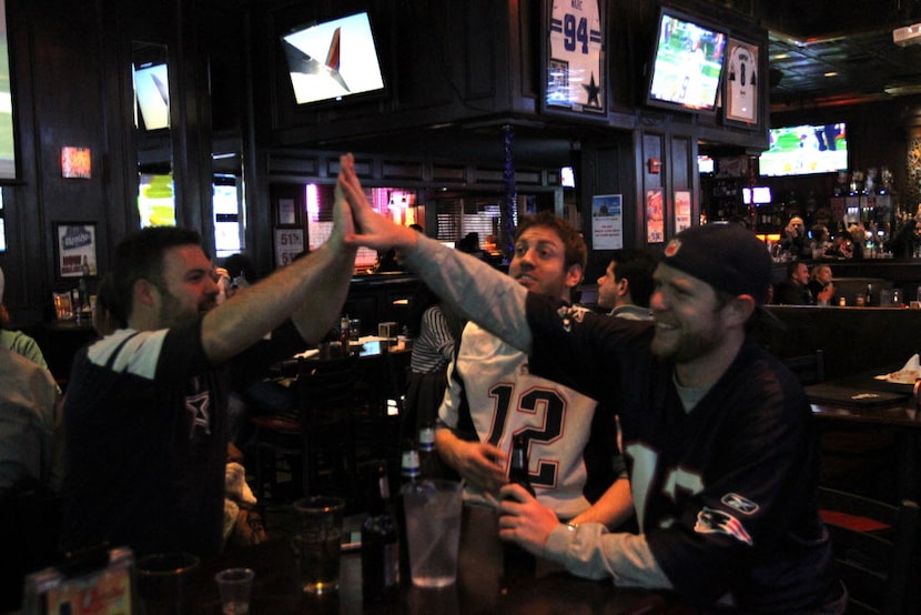 Brandon Johnson, left, and Scott Fagan high five as Matt McCarthy looks on at Christie's...