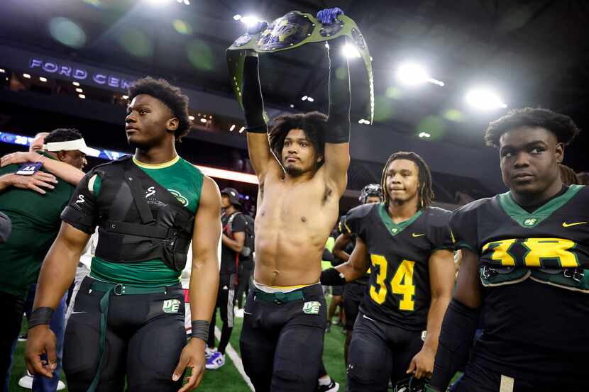 DeSoto linebacker Brandon Booker (center) raises up the belt as he and his teammates...