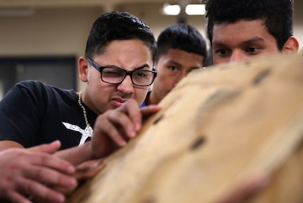 Tenth-grader Andrew Sanchez eyeballs a measurement while constructing a Little Free Library...