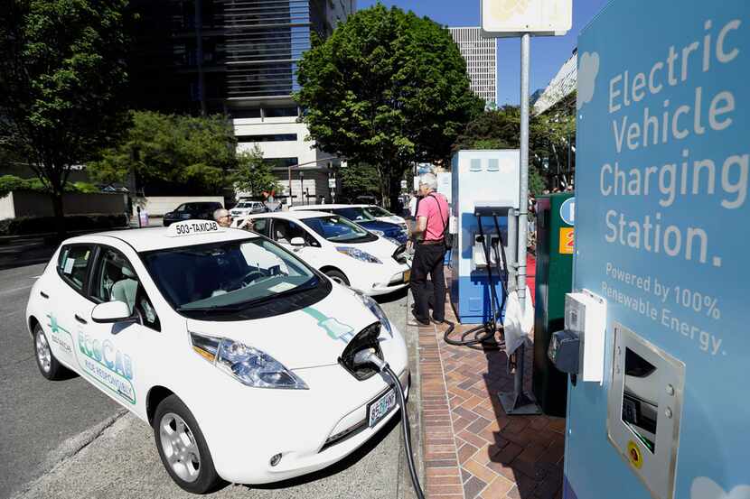 FILE- In this July 28, 2015, file photo, a line of electric cars and newly installed...