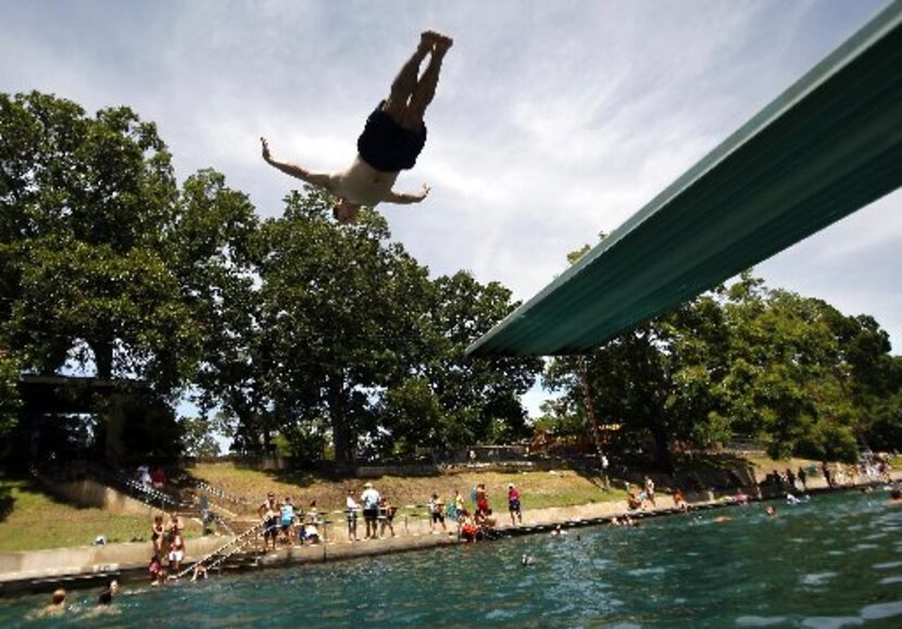 Todd Mouser of Los Angeles dives at Barton Springs Pool during a free swim day.