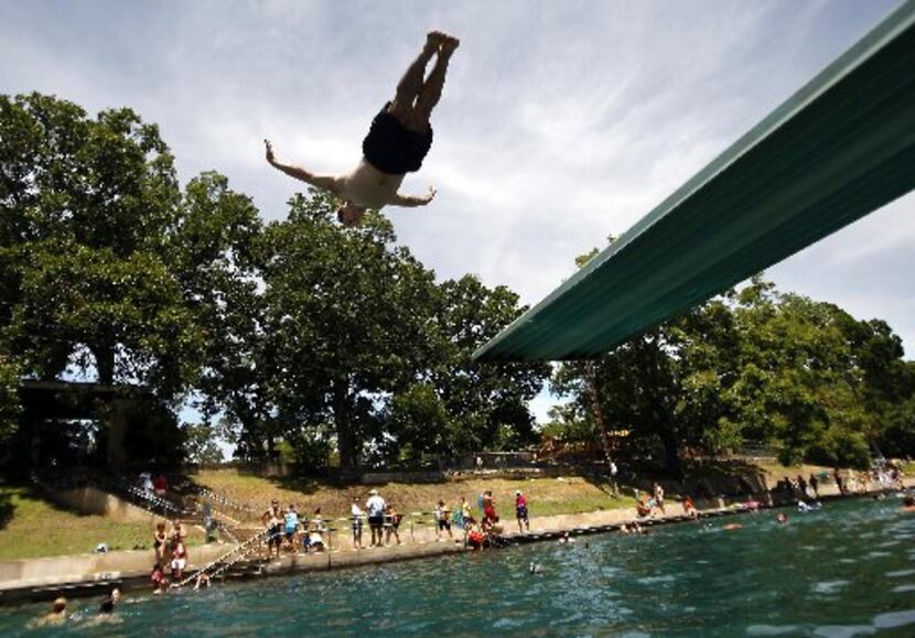 Todd Mouser of Los Angeles dives at Barton Springs Pool during a free swim day.