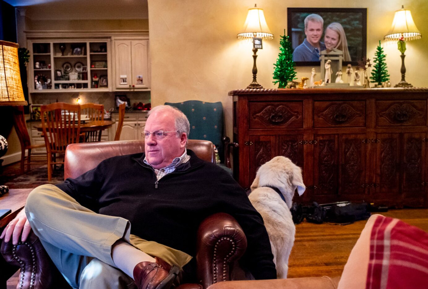 Glen Carter pets his dog, Ace,  as he talks to his wife, Janet, in their University Park.