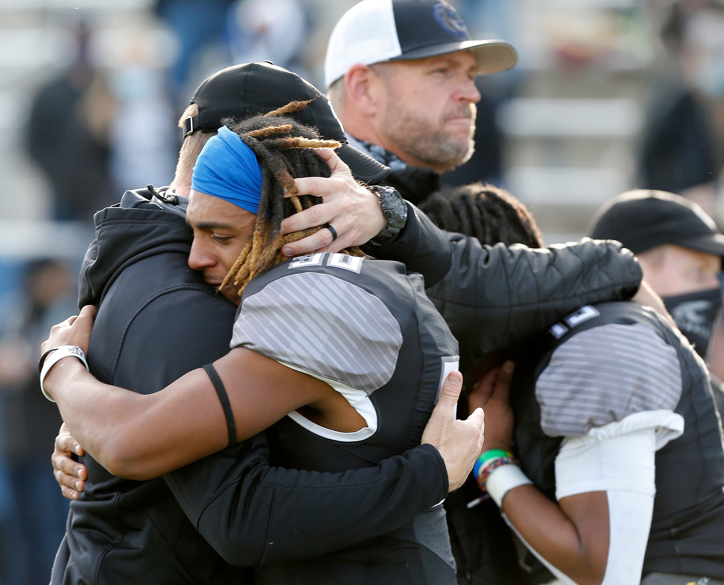 Denton Guyer High School running back Brailynn Pegues (30) is consoled by a coach after the...