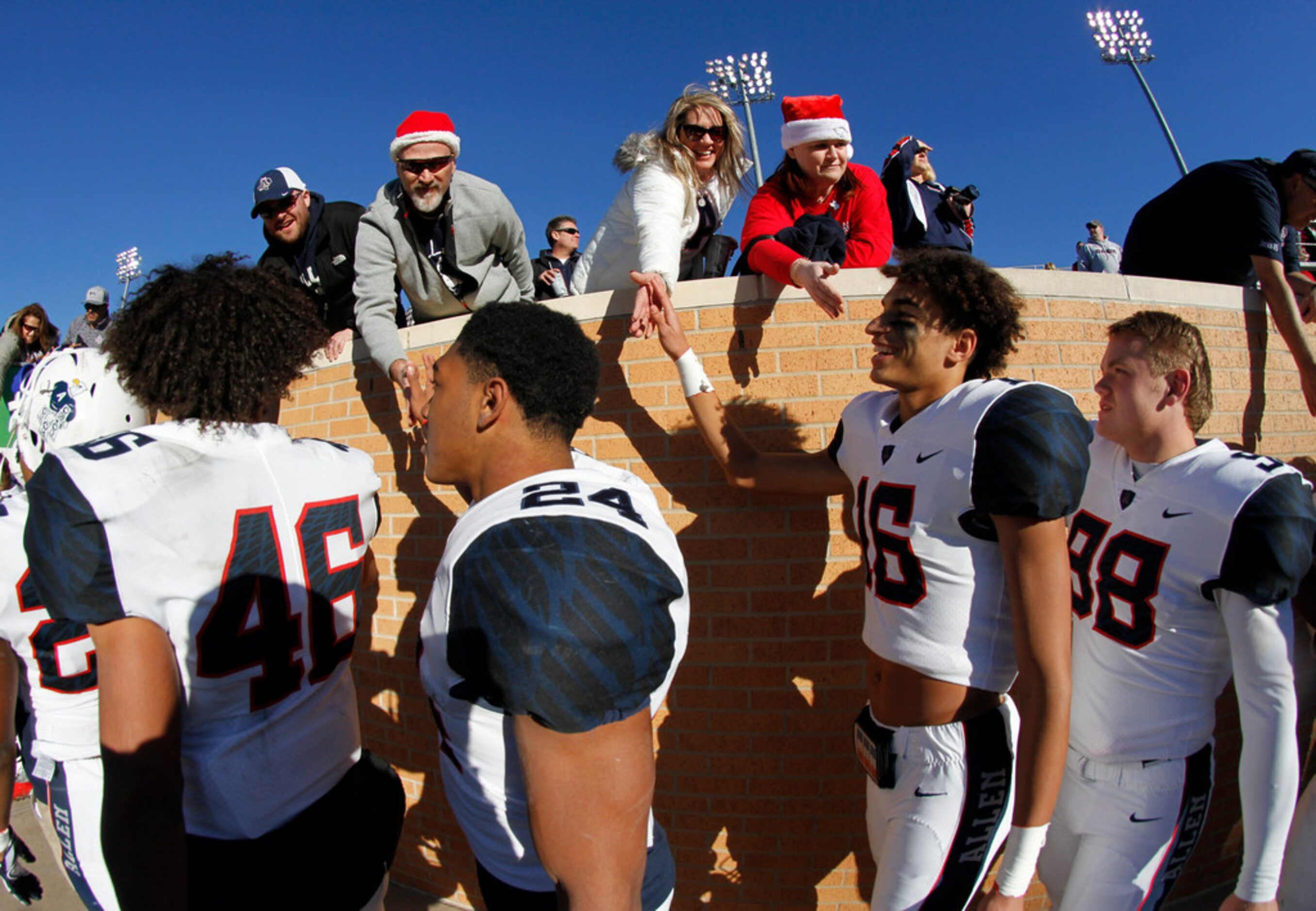 Allen Eagles fans lean over the wall to shake the hands of Eagles players to show their...