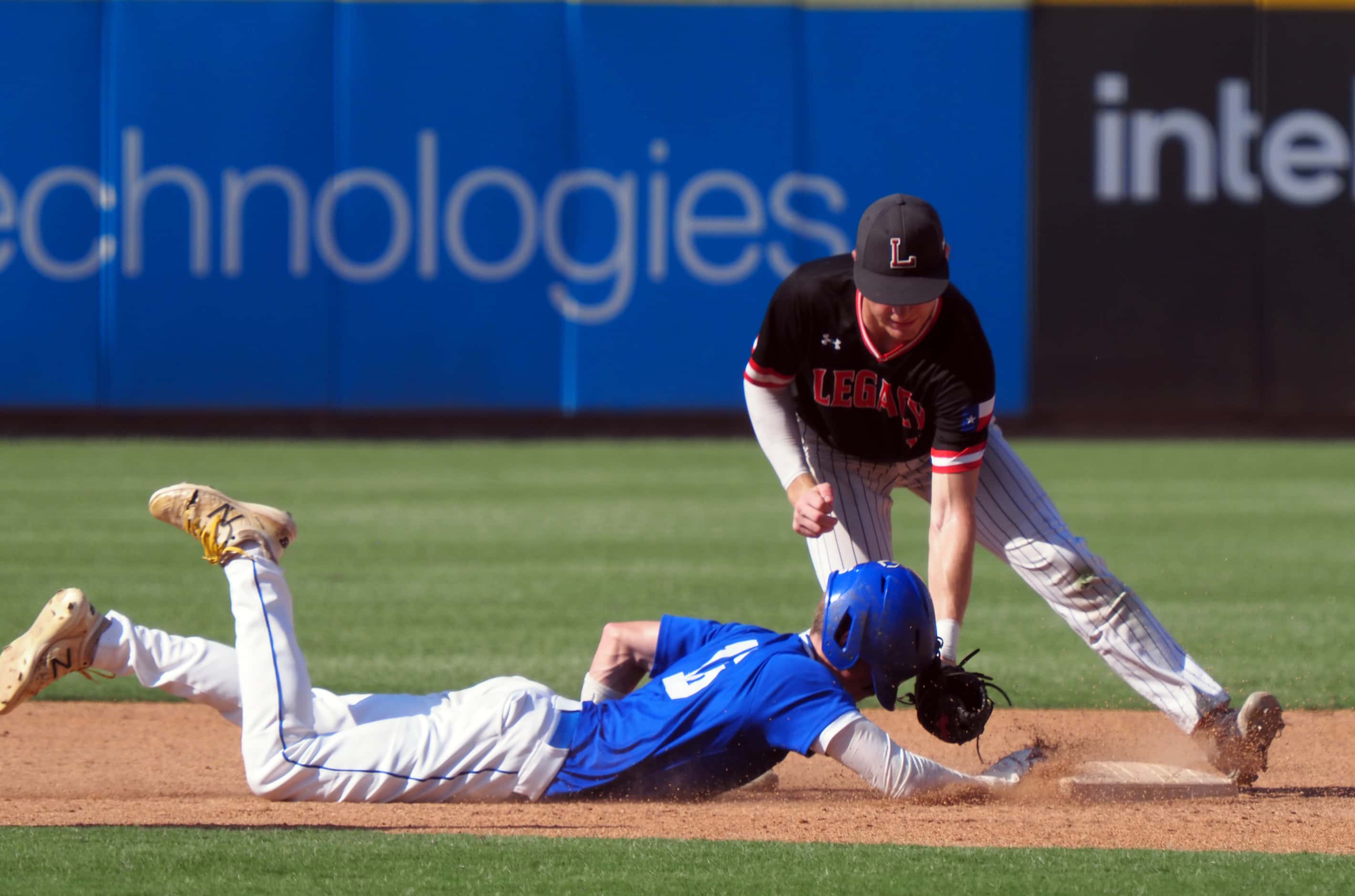 Mansfield Legacy short stop Parker Ibrahimi (right) attempts to tag out Friendswood...