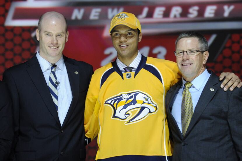 Seth Jones, a defenseman, stands with officials from the Nashville Predators sweater after...
