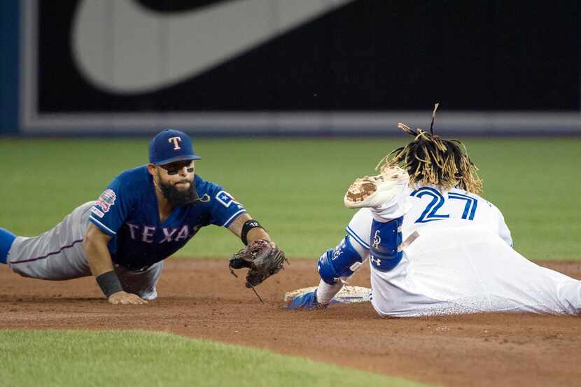 Toronto Blue Jays third baseman Vladimir Guerrero Jr. (27) slides safe past Texas Rangers...