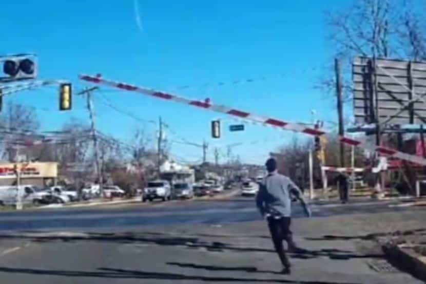 A still image from dashcam video showing a man running toward an elderly woman crossing the...