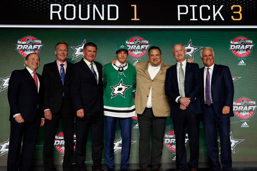 Miro Heiskanen, center, wears a Dallas Stars jersey after being selected by the team in the...