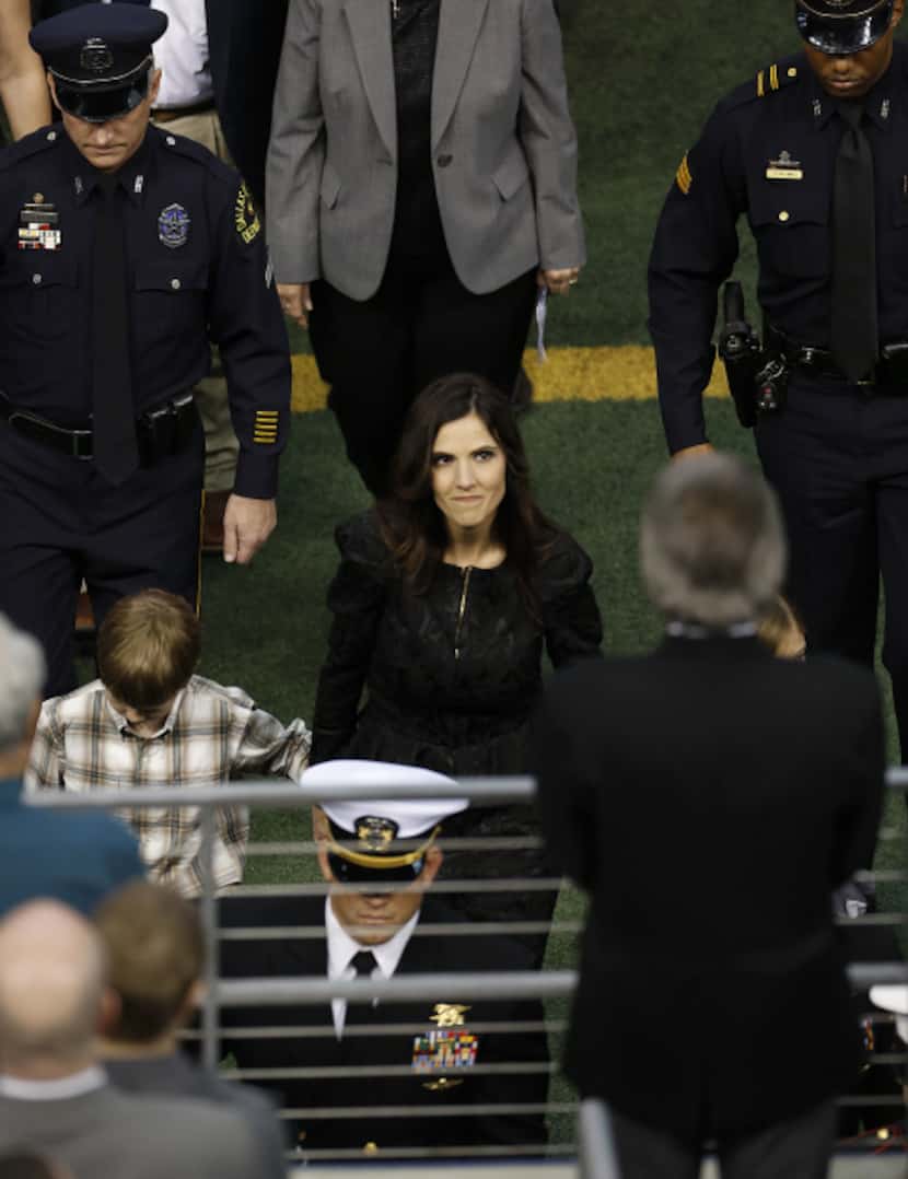 Taya Kyle, center, wife of former Navy SEAL Chris Kyle walks behind the honor guard carrying...