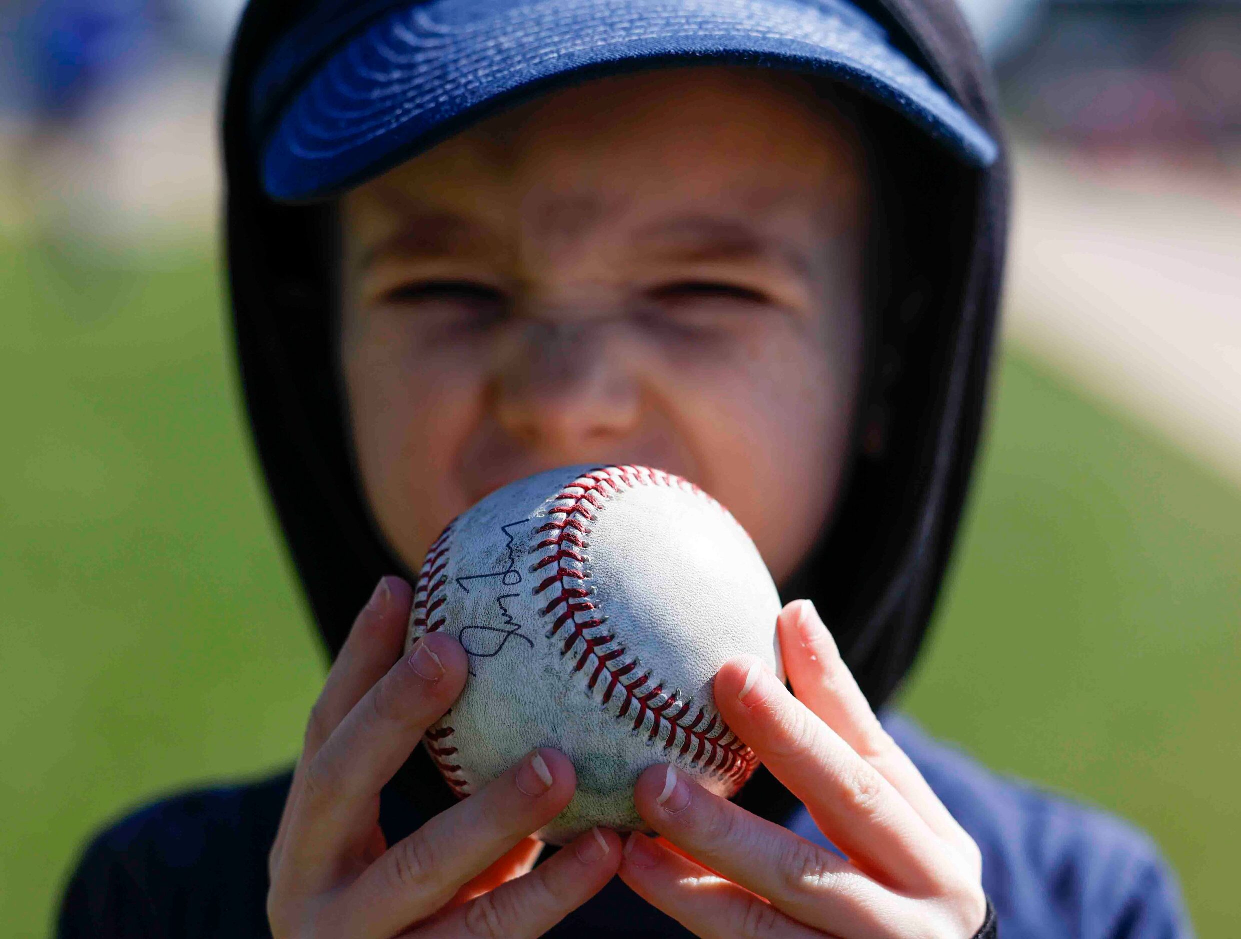 Liam Grahn, 4, of Surprise, Ariz, shows off an autographed ball by Texas Ranger manager...