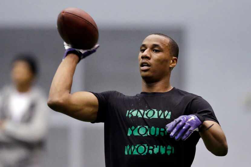 Former Washington player Marcus Peters tosses back a ball as he works out at Washington's...