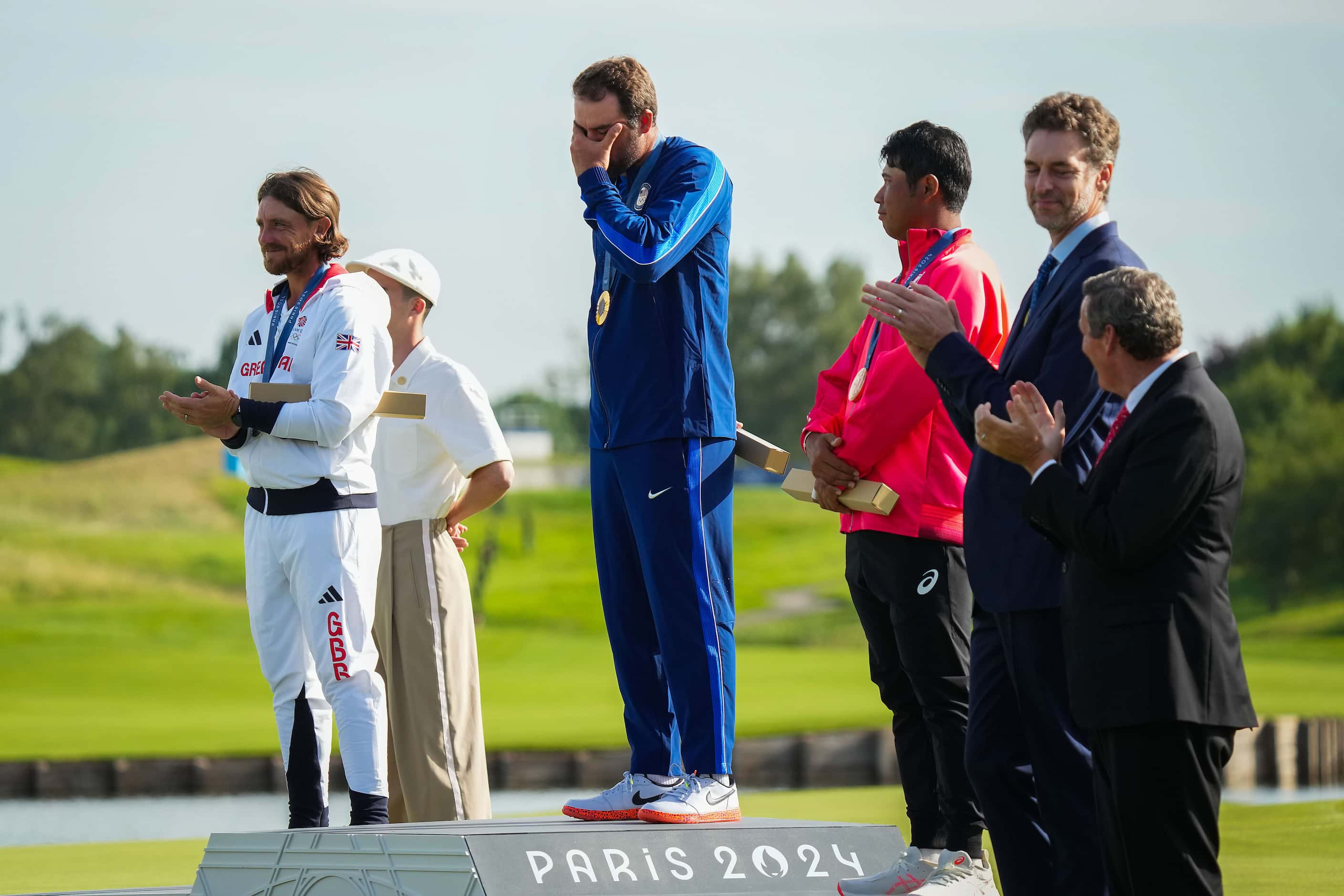 Gold medalist Scottie Scheffler of the United States wipes away tears after the Star...