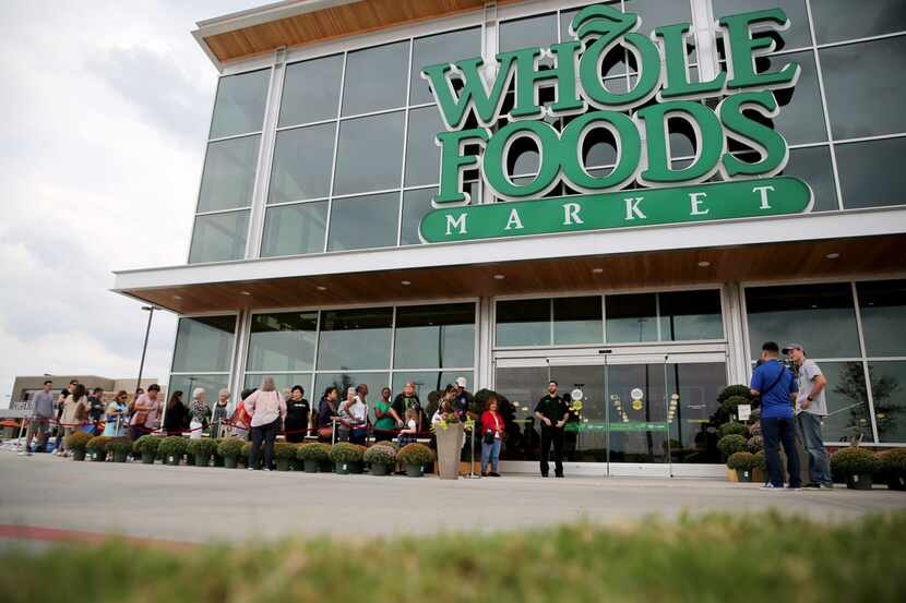 Shoppers line up outside Whole Foods Market during a pre-shopping event at the new Whole...