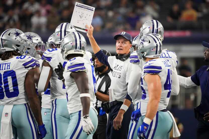 Dallas Cowboys special teams coordinator John Fassel send in a play during the first half of...
