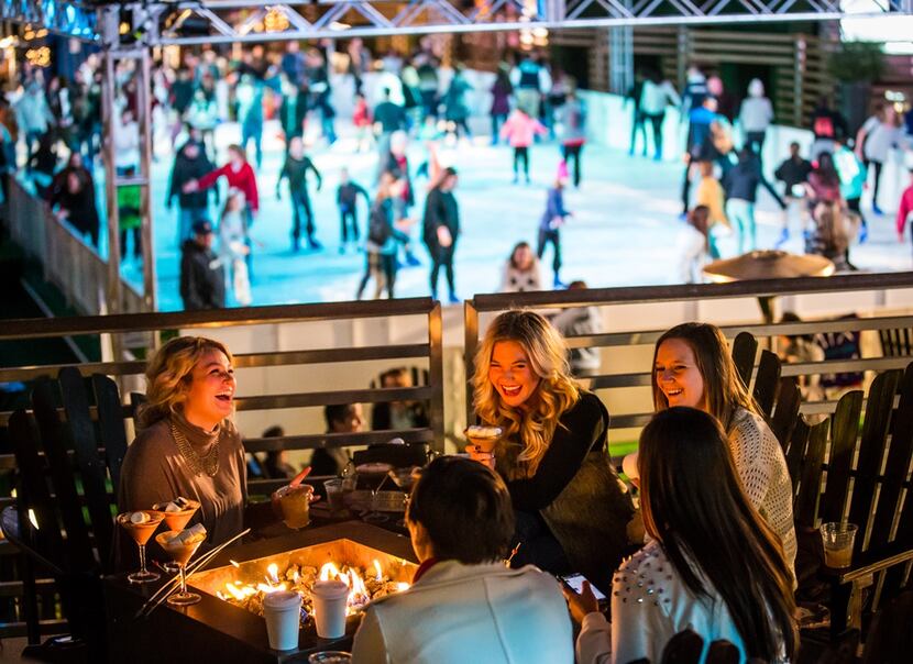 Guests stay warm by a firepit at the Cosmopolitan Resort’s rooftop deck, where the resort...