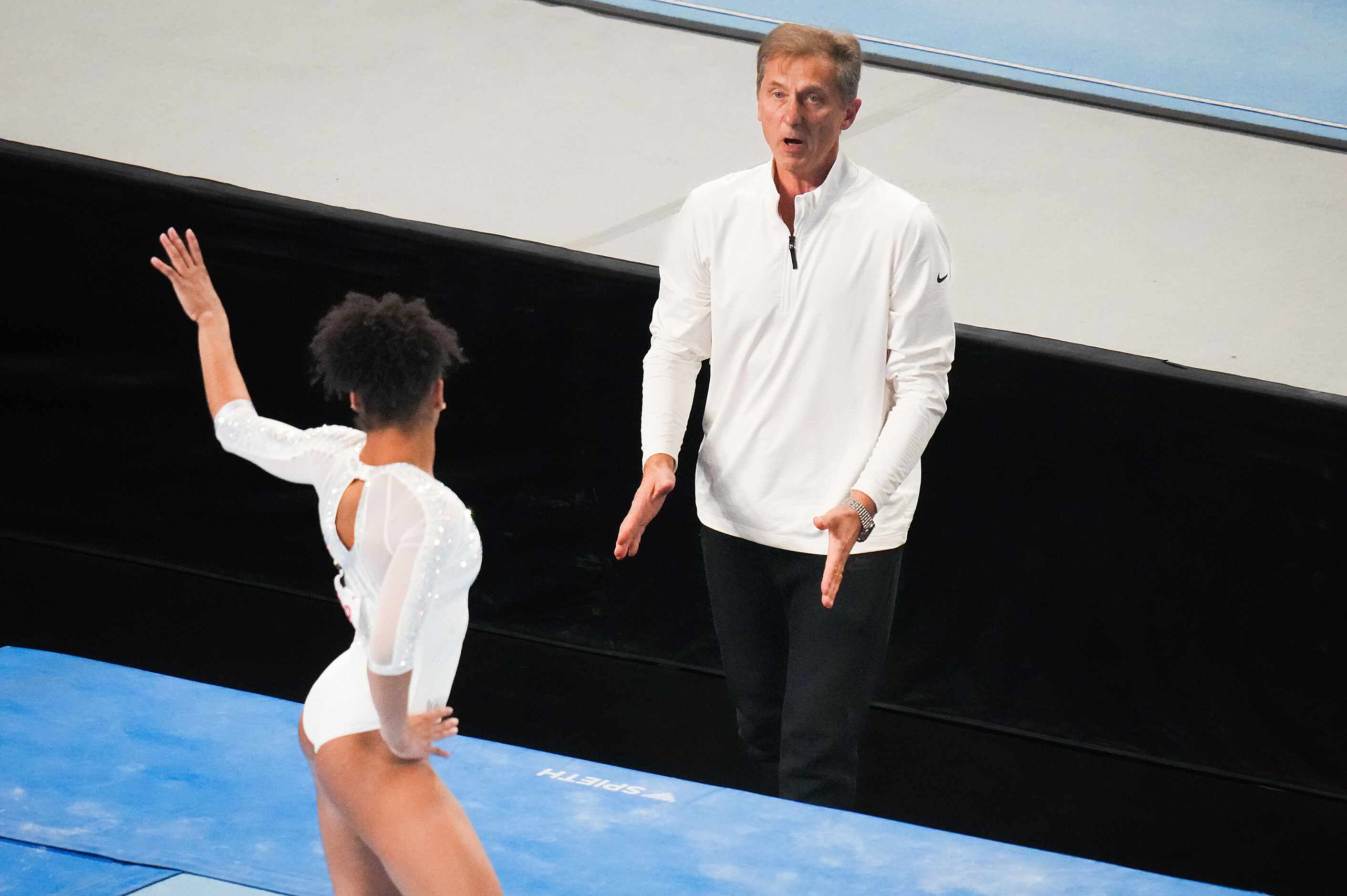 Coach Yevgeny Marchenko claps for Skye Blakely as she competes on the floor during the U.S....