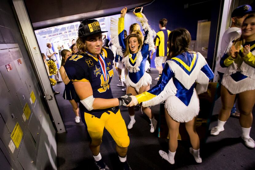 Highland Park defensive lineman Turner Coxe (97) gets a hand from members of the Highland...