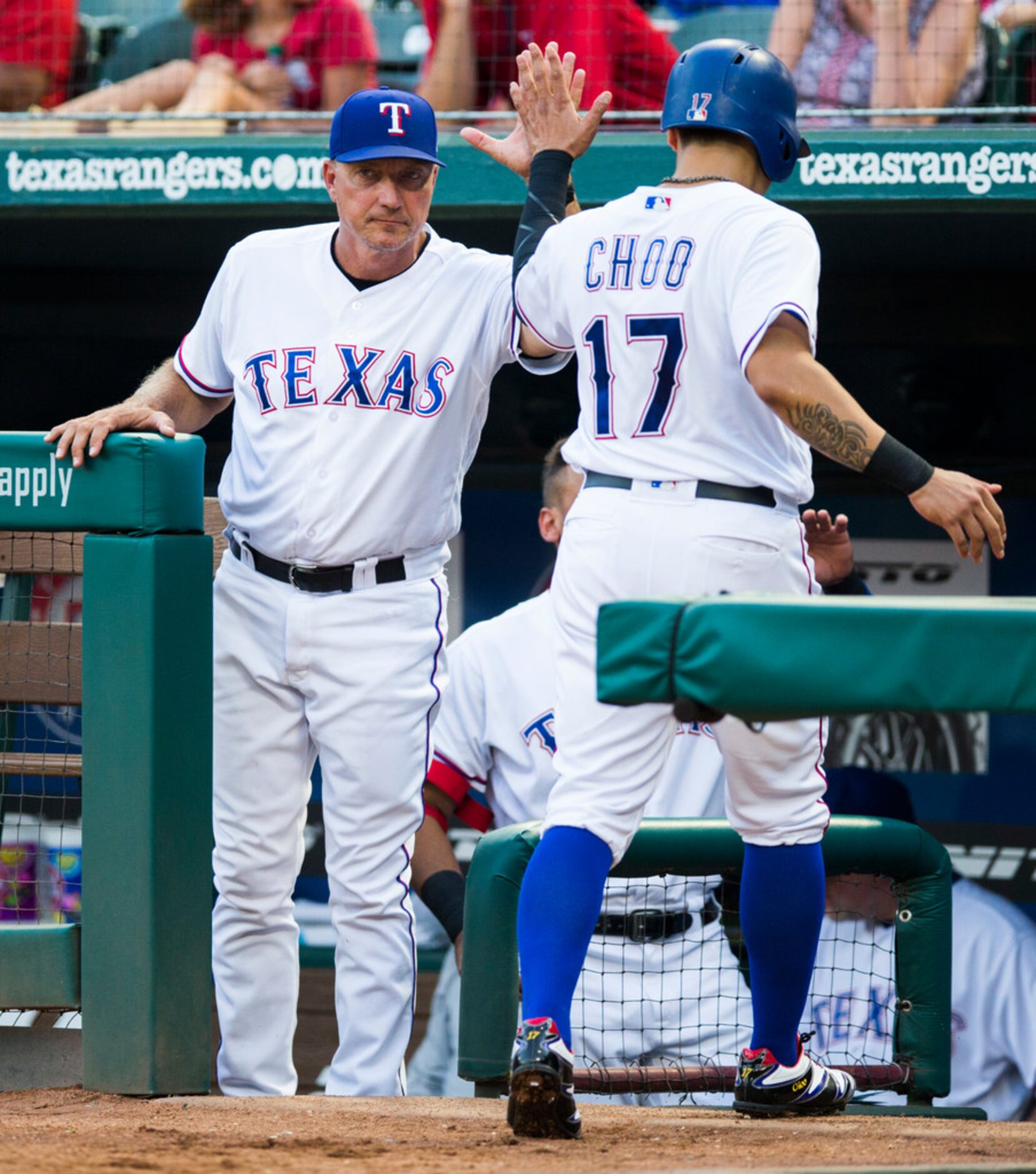 Texas Rangers right fielder Shin-Soo Choo (17) gets a high five from manager Jeff Banister...