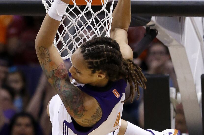 Phoenix Mercury's Brittney Griner hangs on the rim after making a two-handed dunk against...