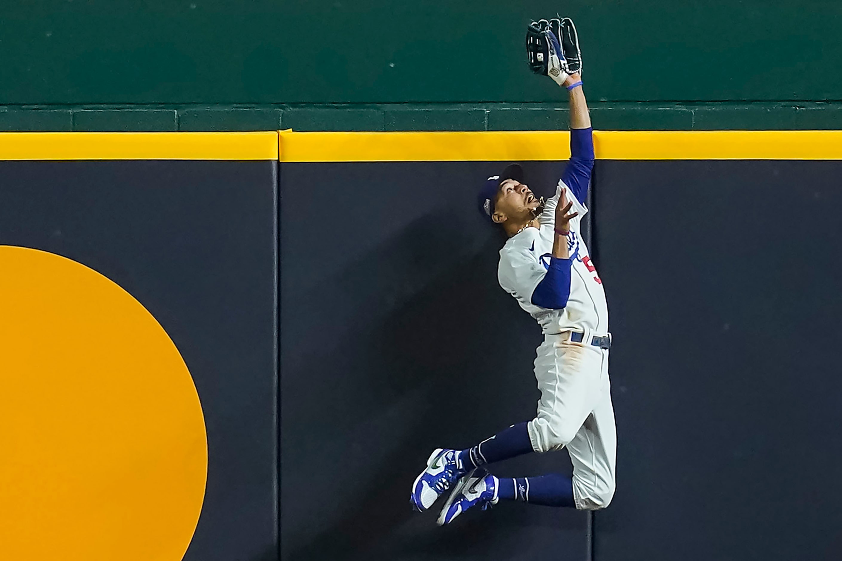 Los Angeles Dodgers right fielder Mookie Betts makes a leaping catch at the wall to take a...