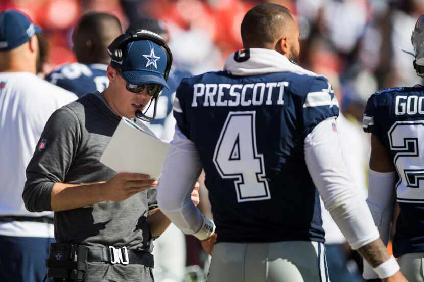 Cowboys offensive coordinator Kellen Moore (left) talks with quarterback Dak Prescott (4) on...