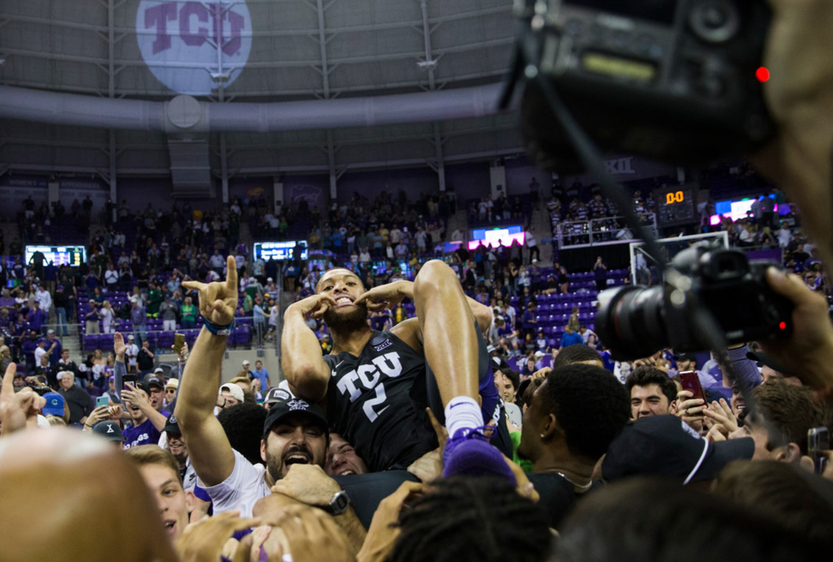 TCU Horned Frogs guard Edric Dennis (2) celebrates after fans rush the court because of a...