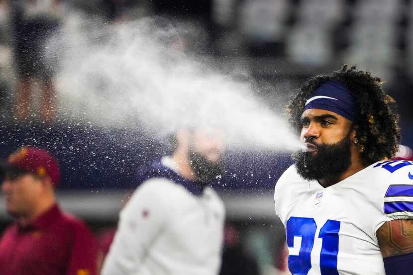 Ezekiel Elliott, former Dallas Cowboys running back, blows water while warming up before an...