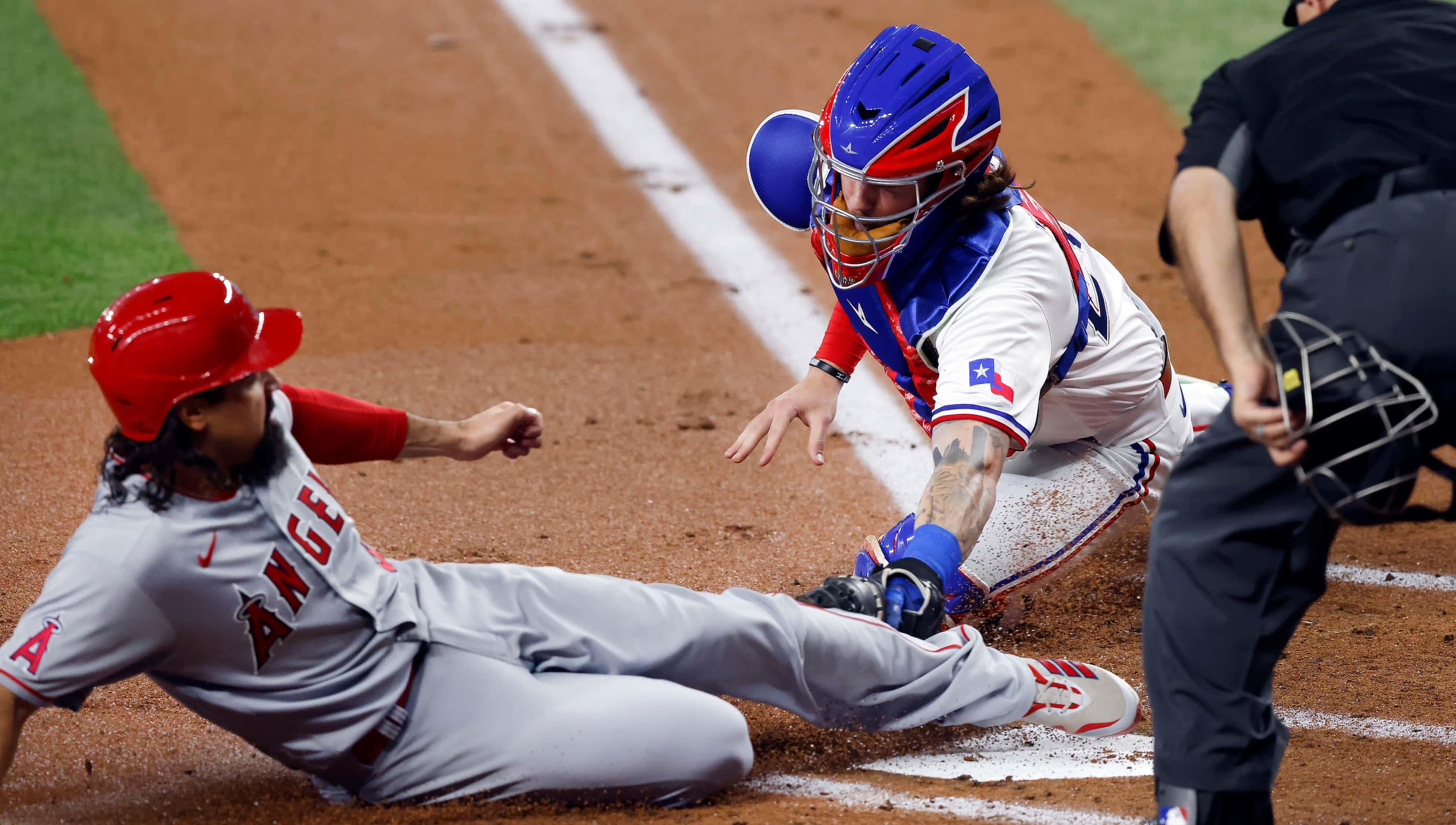 Texas Rangers catcher Jonah Heim (28) is late with the tag as Los Angeles Angels Anthony...