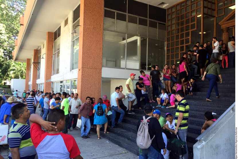 Centenares de migrantes de Centroamérica forman a diario largas filas ante las oficinas de...