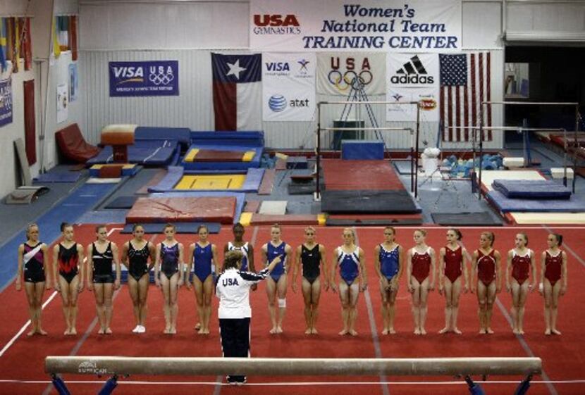 Gymnasts line up on the floor at the end of a training session to listen to National...