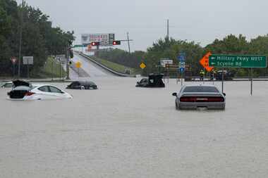 Stalled cars sit abandoned on the flooded Interstate 635 Service Road on Monday, Aug. 22,...