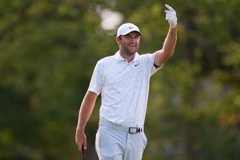 Scottie Scheffler gestures for someone to clear the 18th fairway before hitting from the...