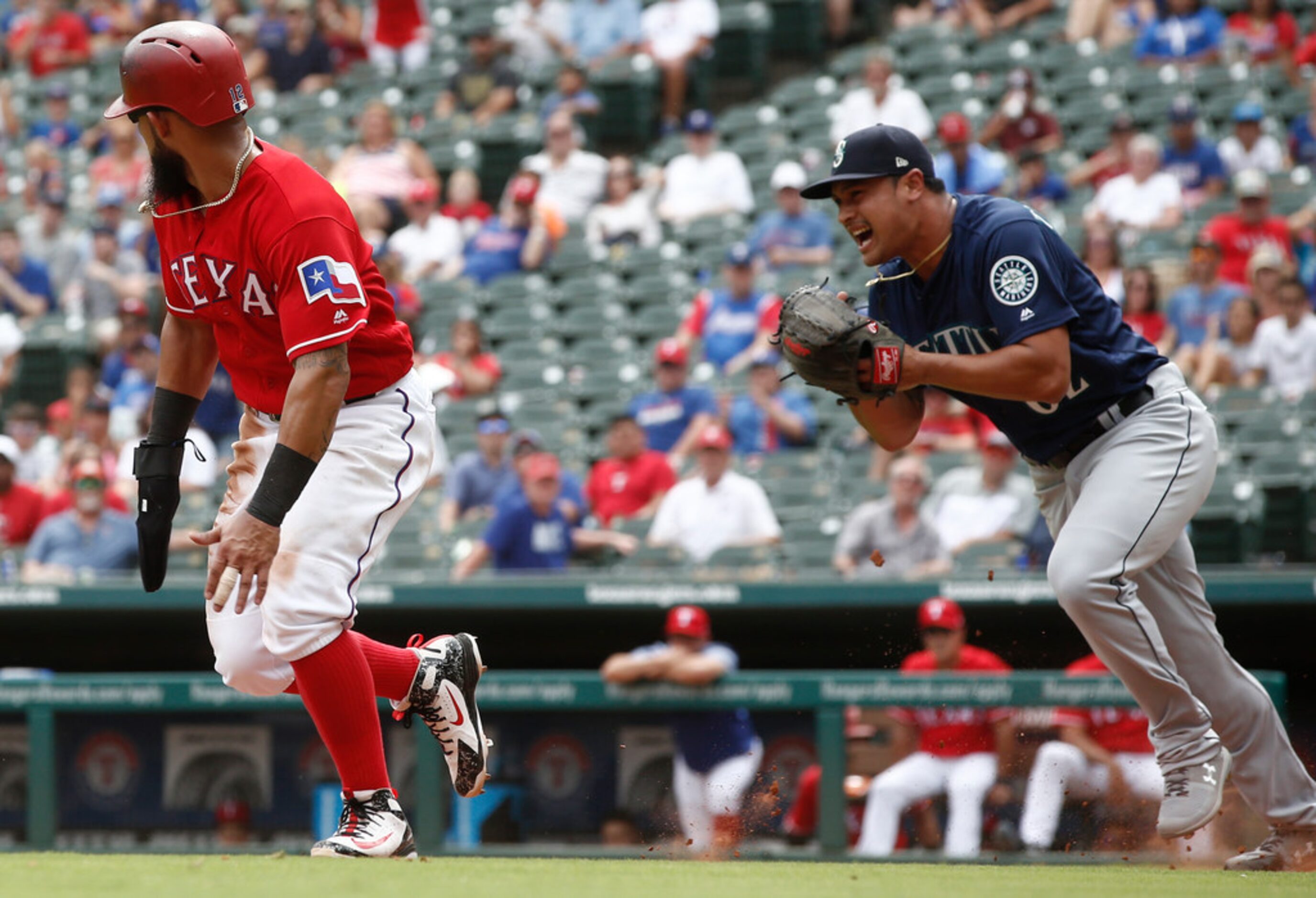 Seattle Mariners pitcher Sam Tuivailala (62) grimaces after handling the ball as Texas...