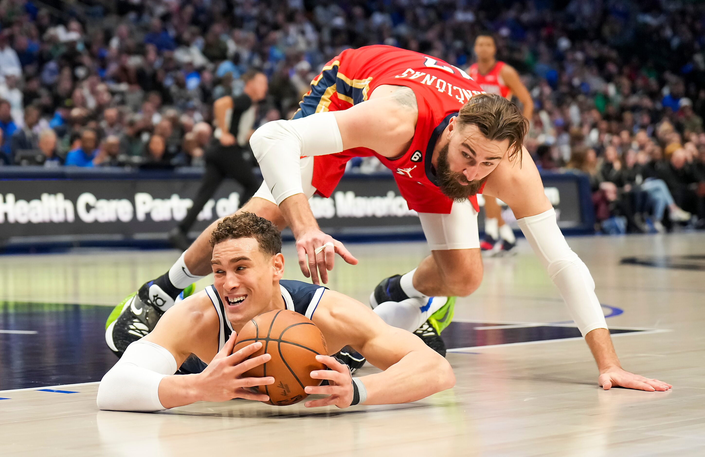 Dallas Mavericks center Dwight Powell (7) dives for a loose ball against New Orleans...