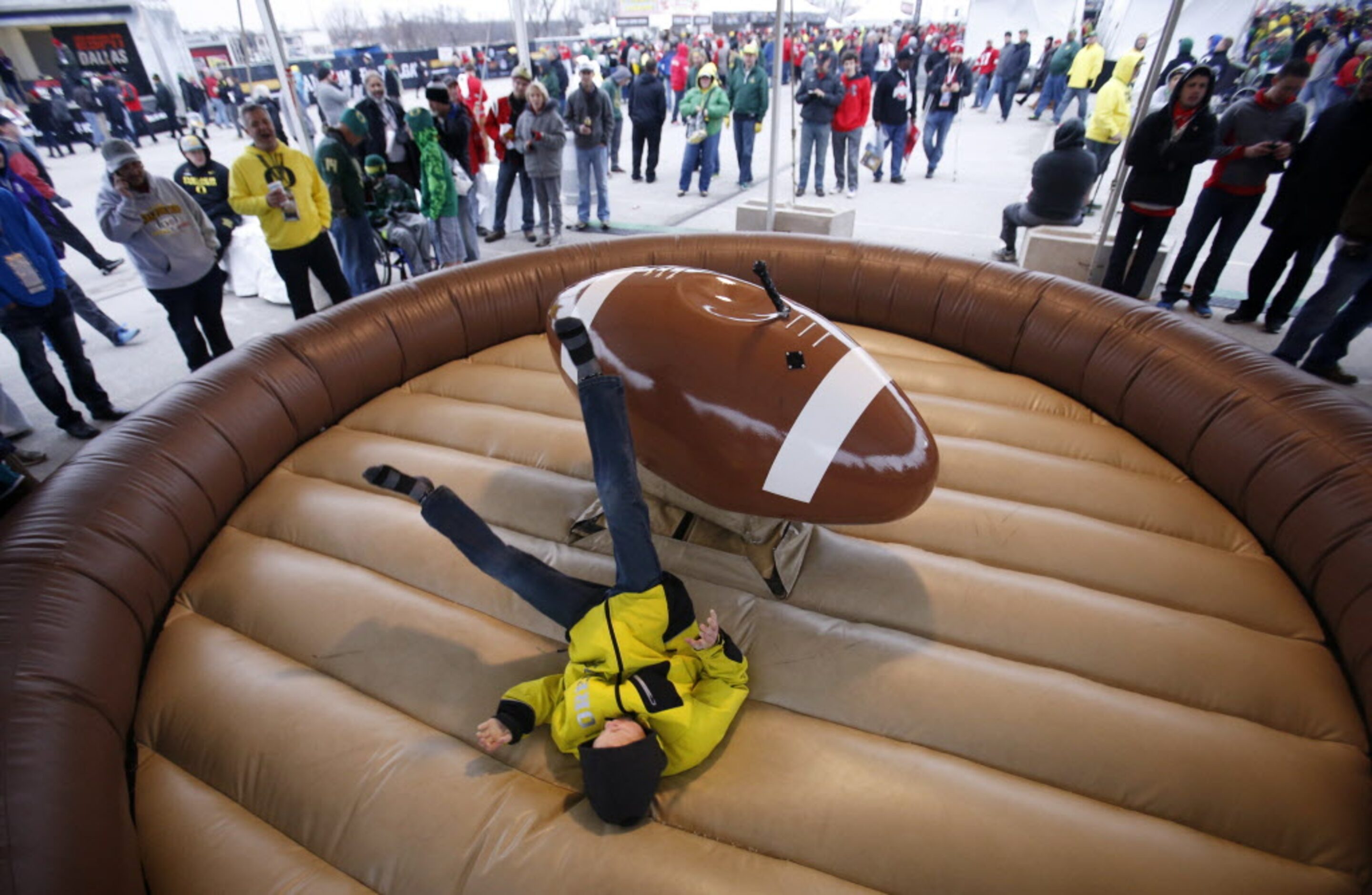 Ethan Cross, 11 of Eugene,Oregon falls off as he rides the "footbull" before a game between...