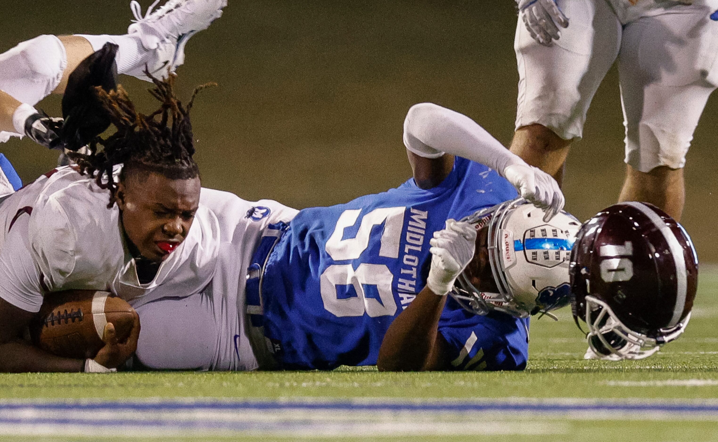 Midlothian linebacker Ny’tori Burnett (58) rips the helmet off  Red Oak quarterback Jaylon...