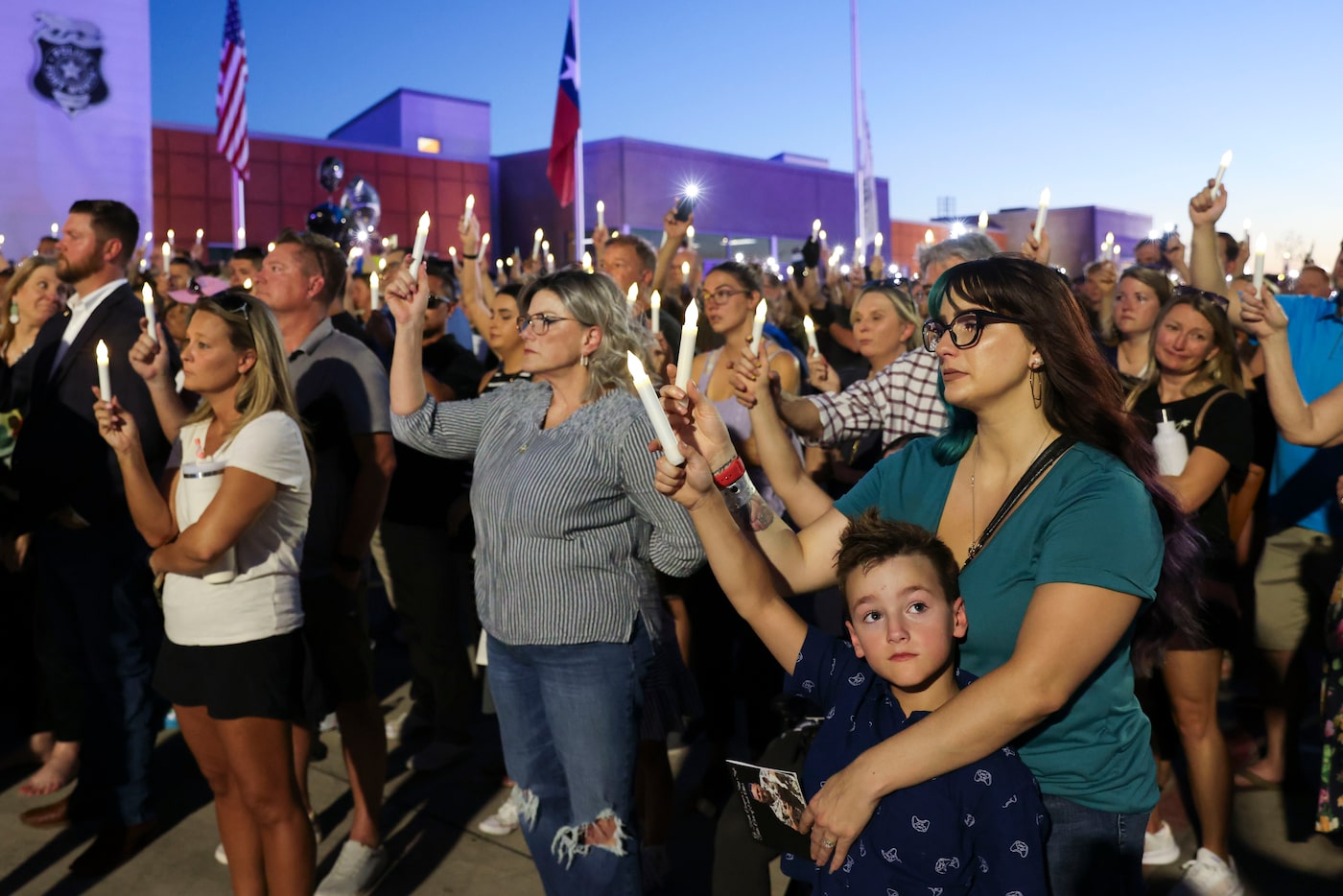 Kayla Rogers (right) with her son Brett, 7, hold a candle during a vigil honoring Fort Worth...