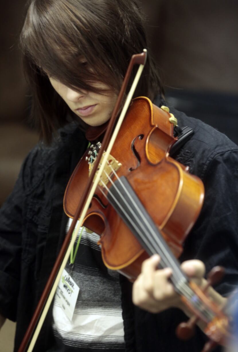 Nicholas Langlois , 15, plays the viola in a class taught by Marcus Pyle, a 23-year-old...