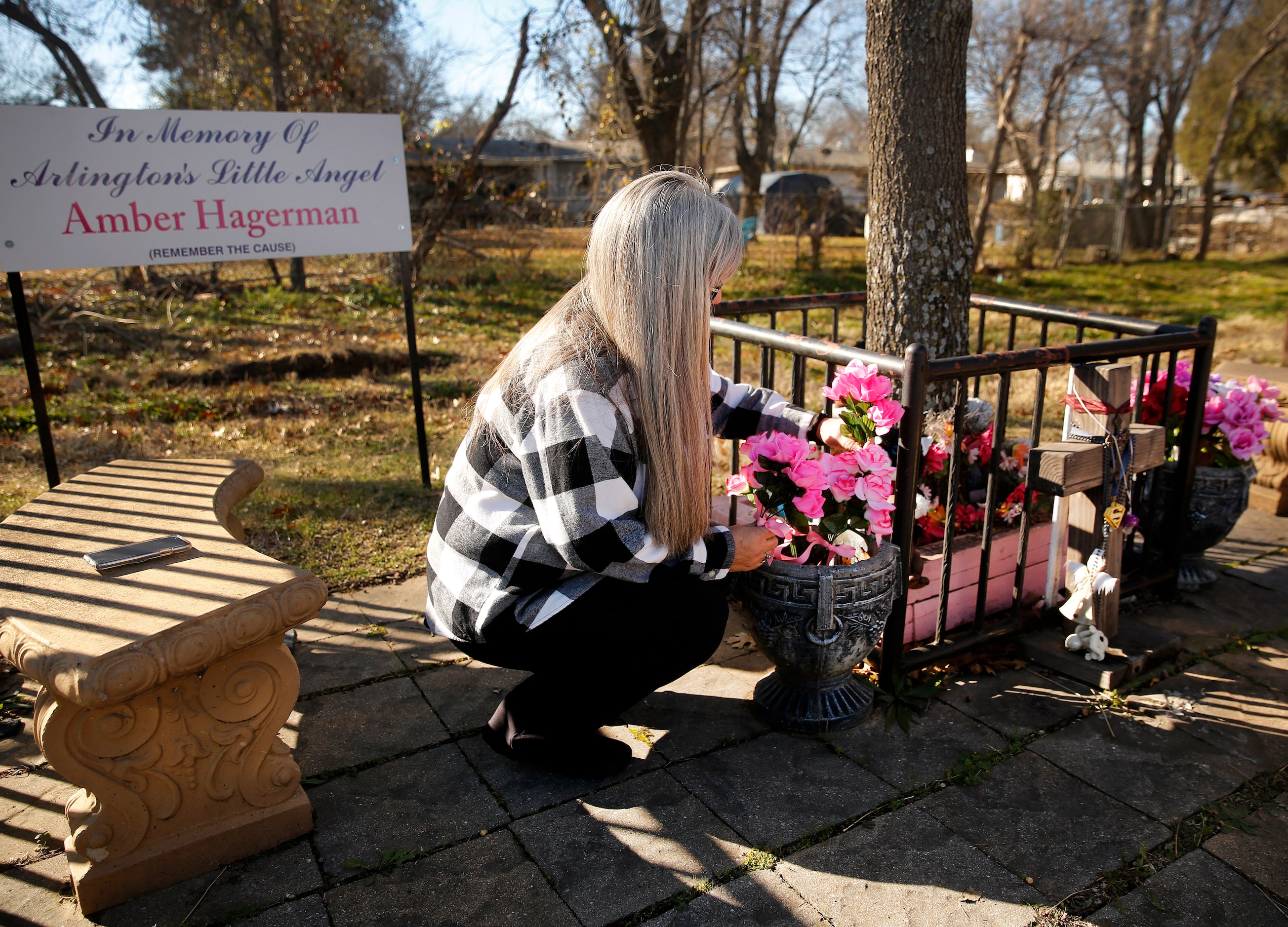 Amber Hagerman's mother Donna Williams places new flowers at a permanent memorial for her...